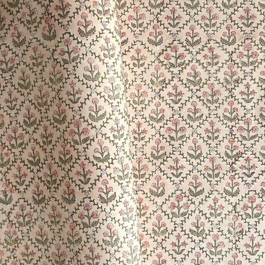 a sheet of hand block printed wrapping paper with a floral trellis design in coral pink and sage green