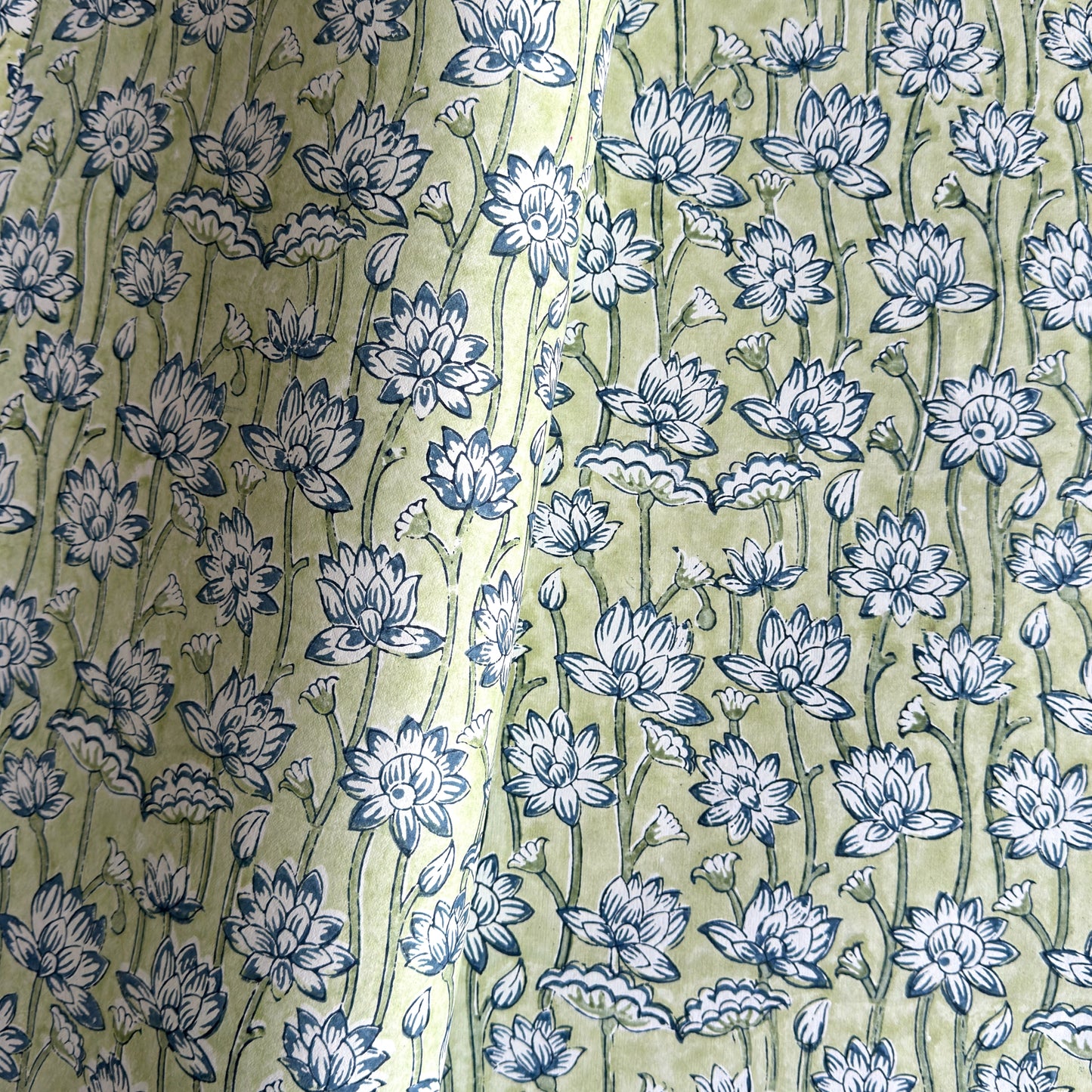hand block printed wrapping paper with a repeat lotus flower design in indigo and light green. By Paper Mirchi