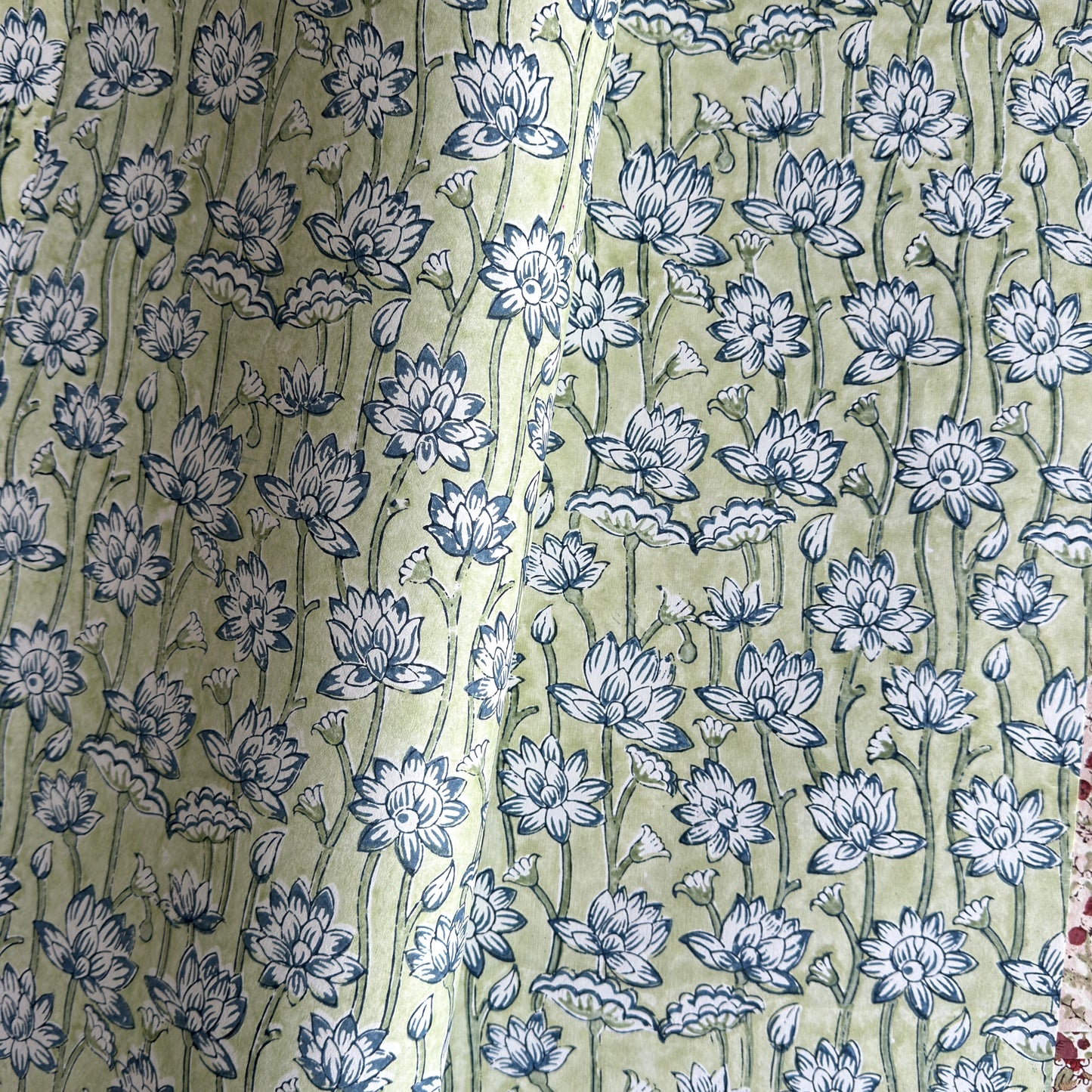 hand block printed wrapping paper with a repeat lotus flower design in indigo and light green. By Paper Mirchi