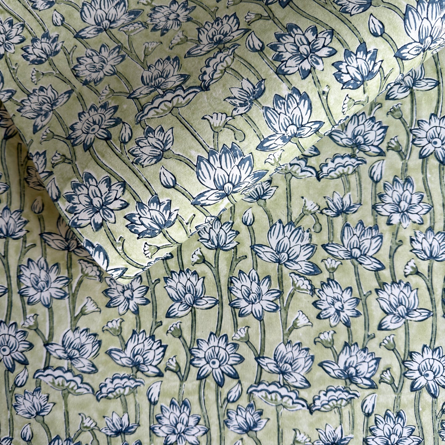 hand block printed wrapping paper with a repeat lotus flower design in indigo and light green. By Paper Mirchi