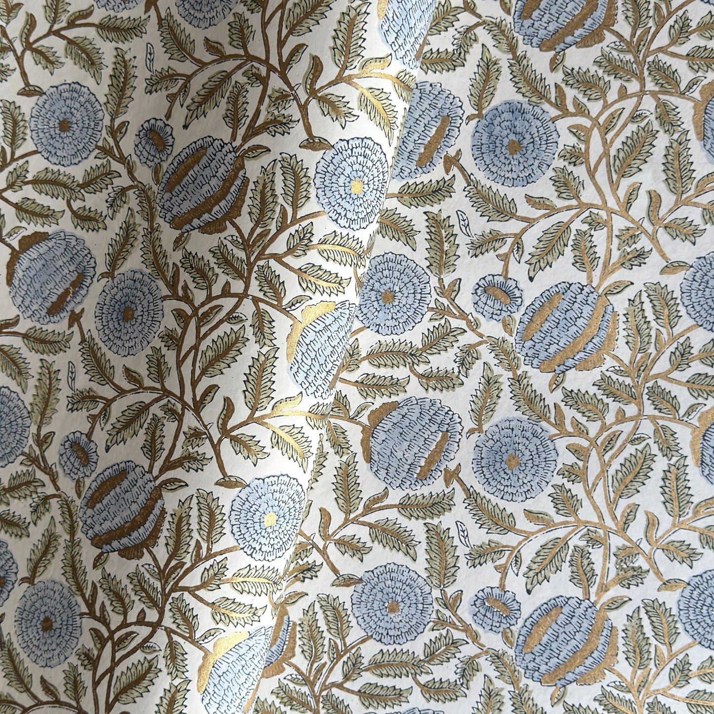 wrapping paper with repeat botanical pattern in blue, gold and green by Paper Mirchi