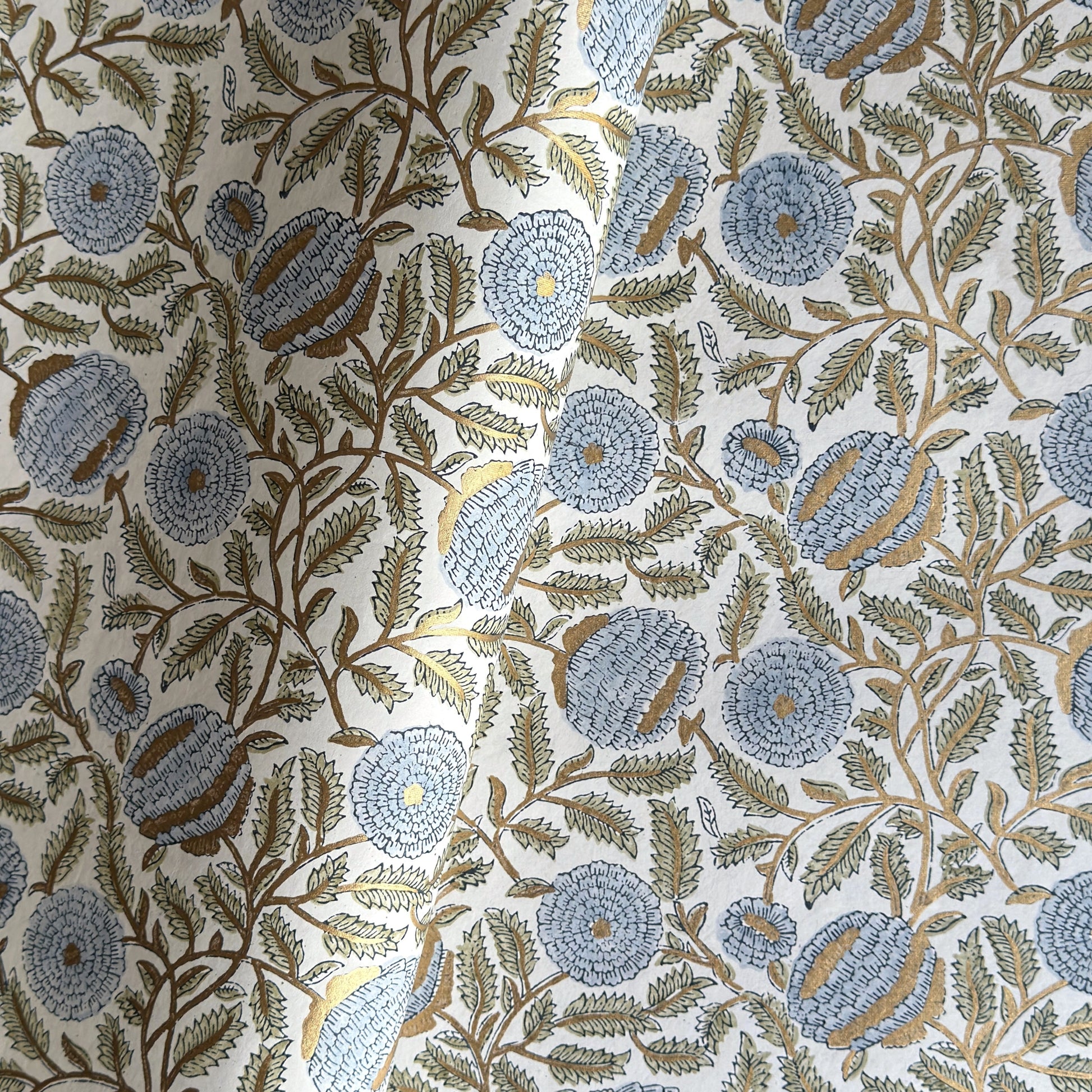 wrapping paper with repeat botanical pattern in blue, gold and green by Paper Mirchi