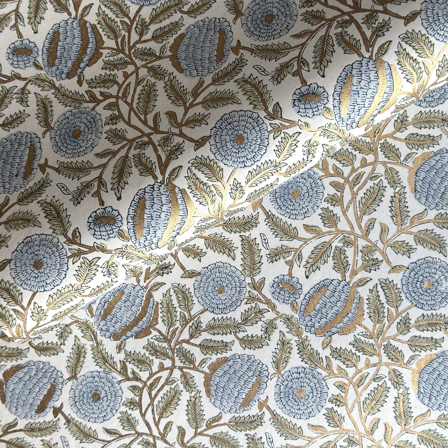 wrapping paper with repeat botanical pattern in blue, gold and green by Paper Mirchi