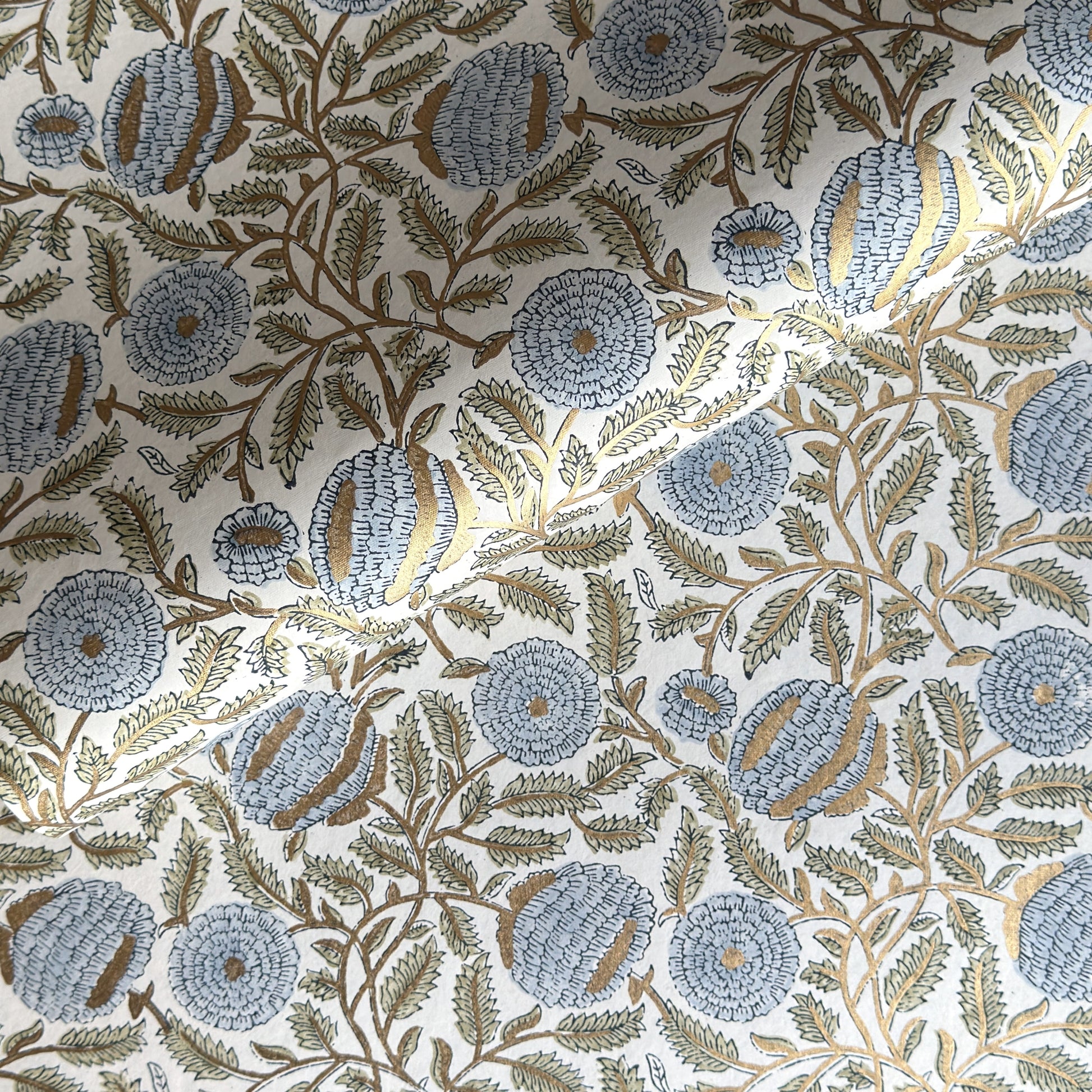 wrapping paper with repeat botanical pattern in blue, gold and green by Paper Mirchi