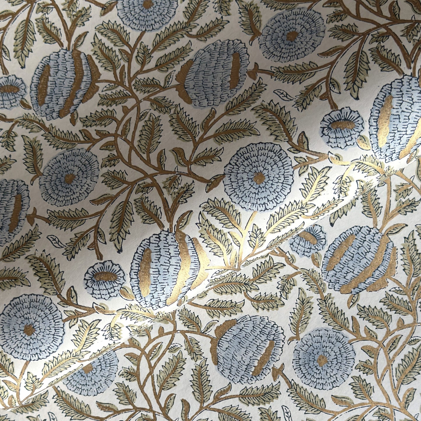 wrapping paper with repeat botanical pattern in blue, gold and green by Paper Mirchi