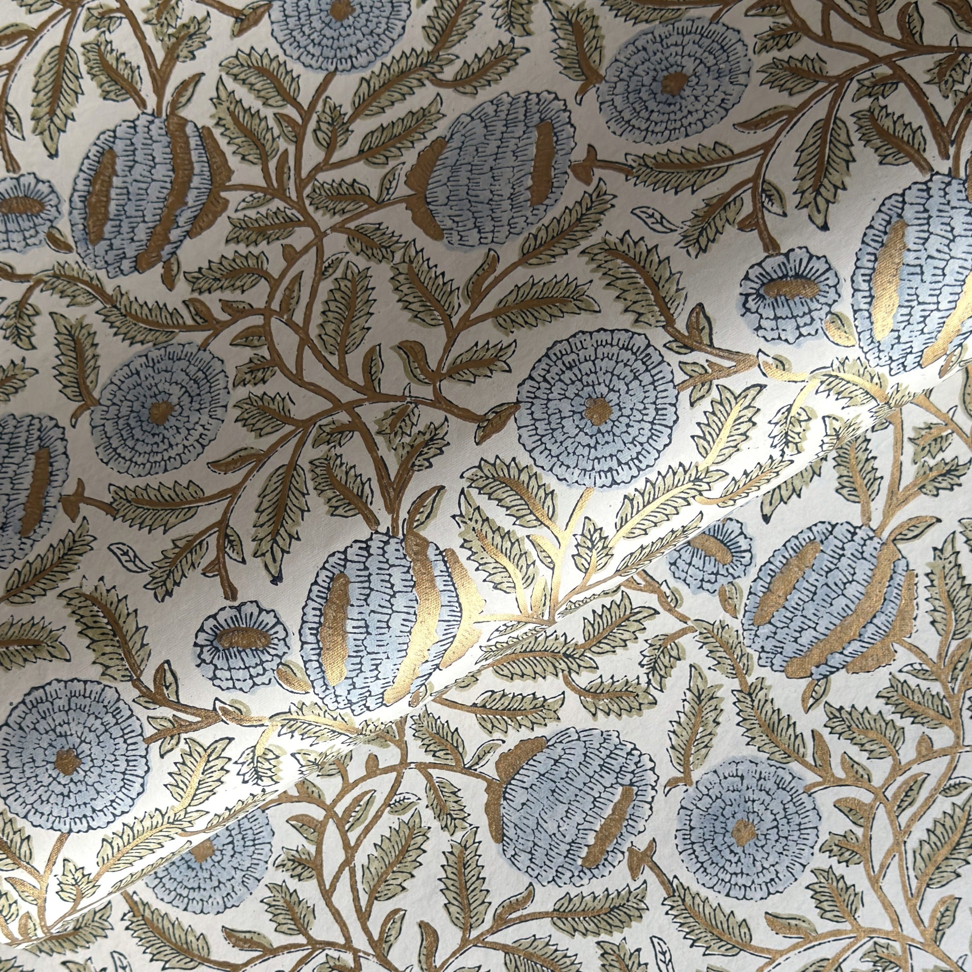 wrapping paper with repeat botanical pattern in blue, gold and green by Paper Mirchi
