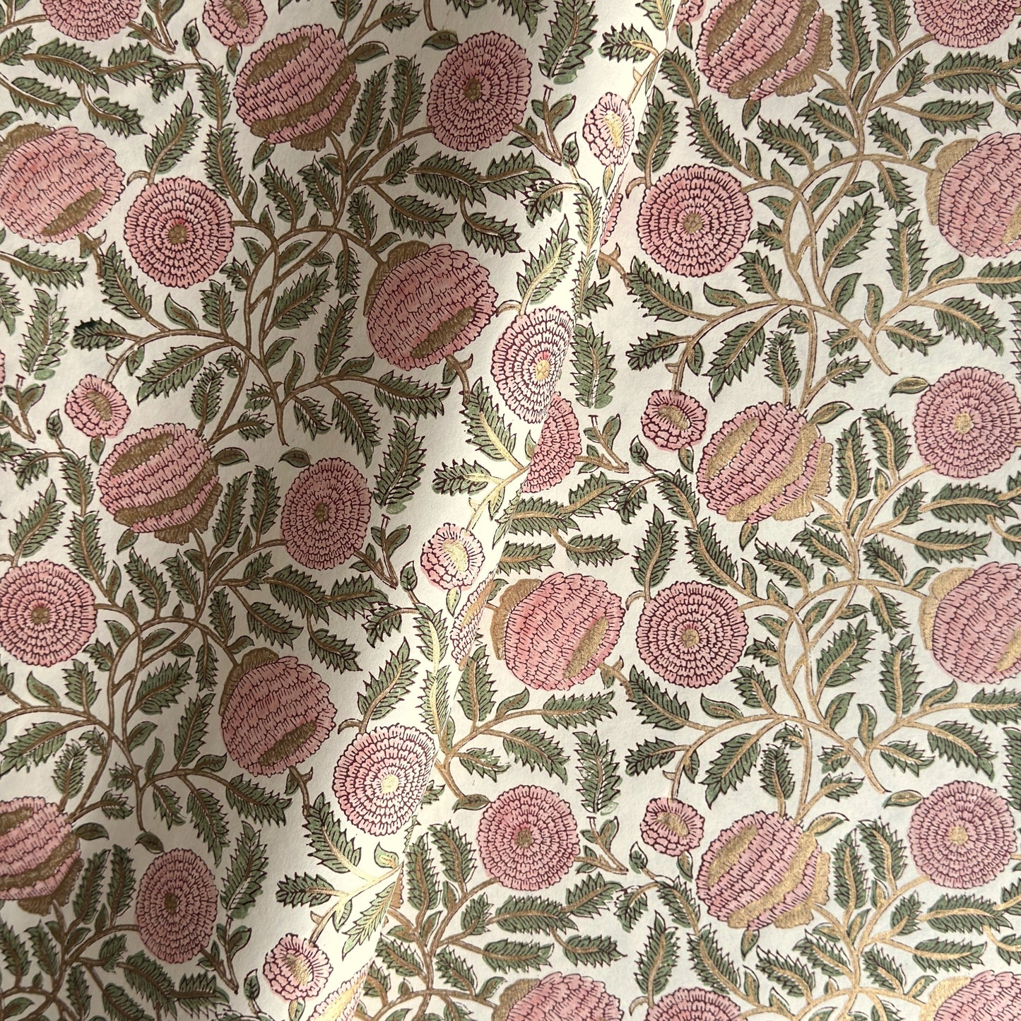 wrapping paper with repeat botanical pattern in pink, gold and green by Paper Mirchi