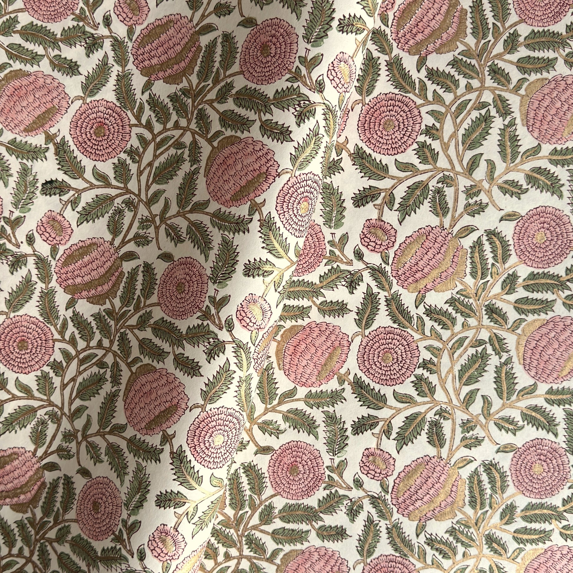 wrapping paper with repeat botanical pattern in pink, gold and green by Paper Mirchi