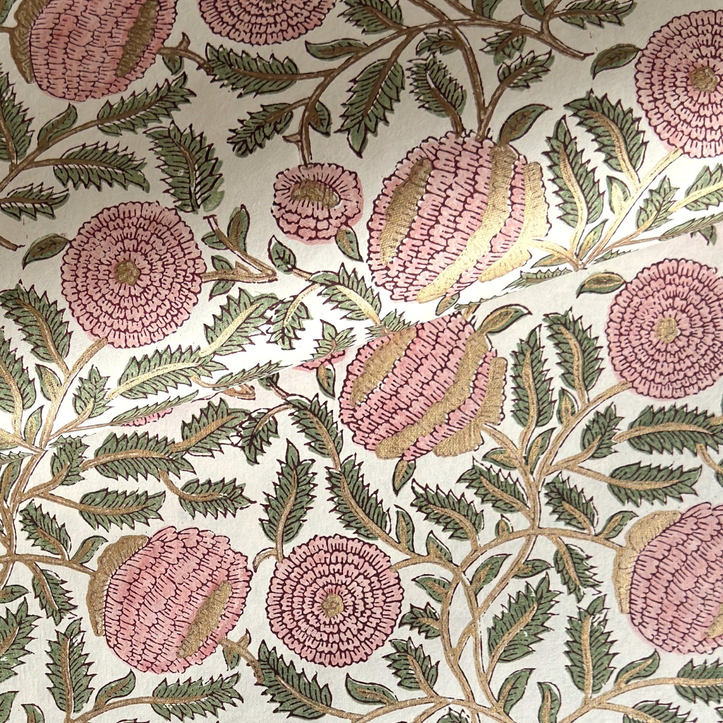 wrapping paper with repeat botanical pattern in pink, gold and green by Paper Mirchi