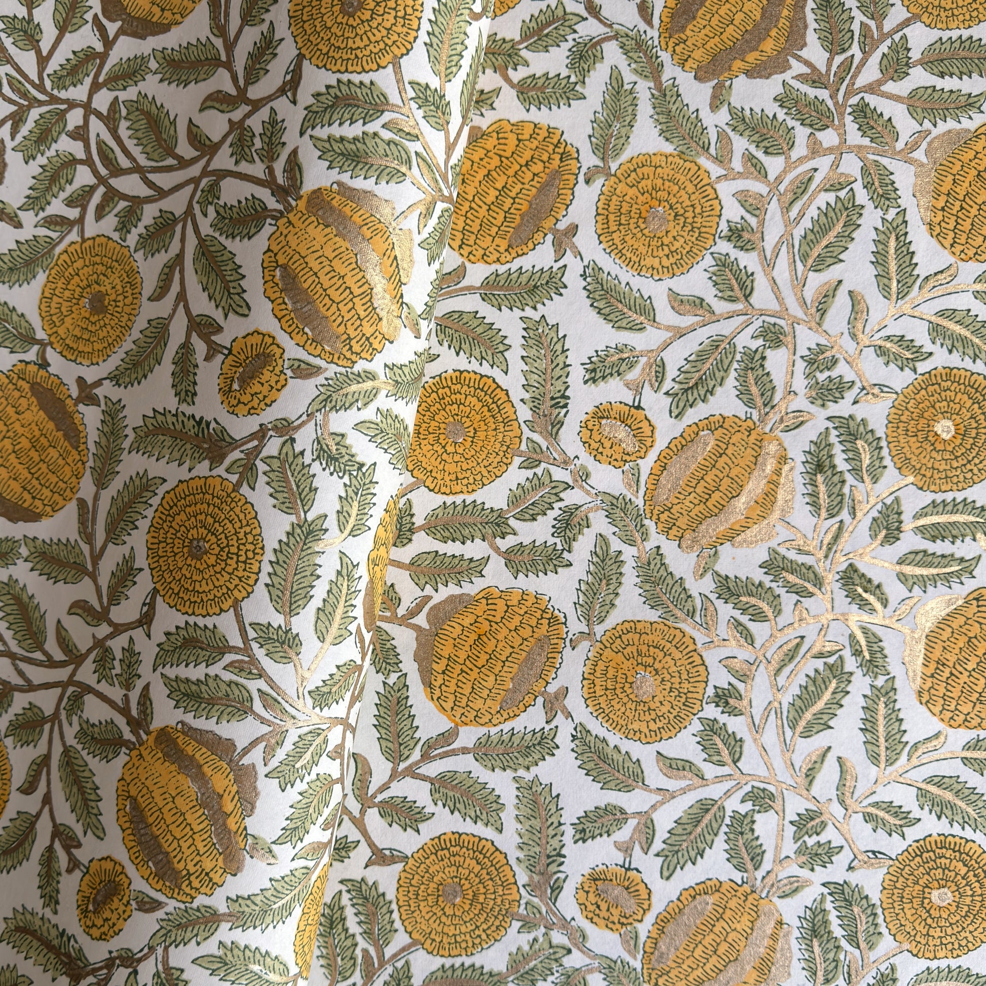 wrapping paper with repeat botanical pattern in yellow, gold and green by Paper Mirchi