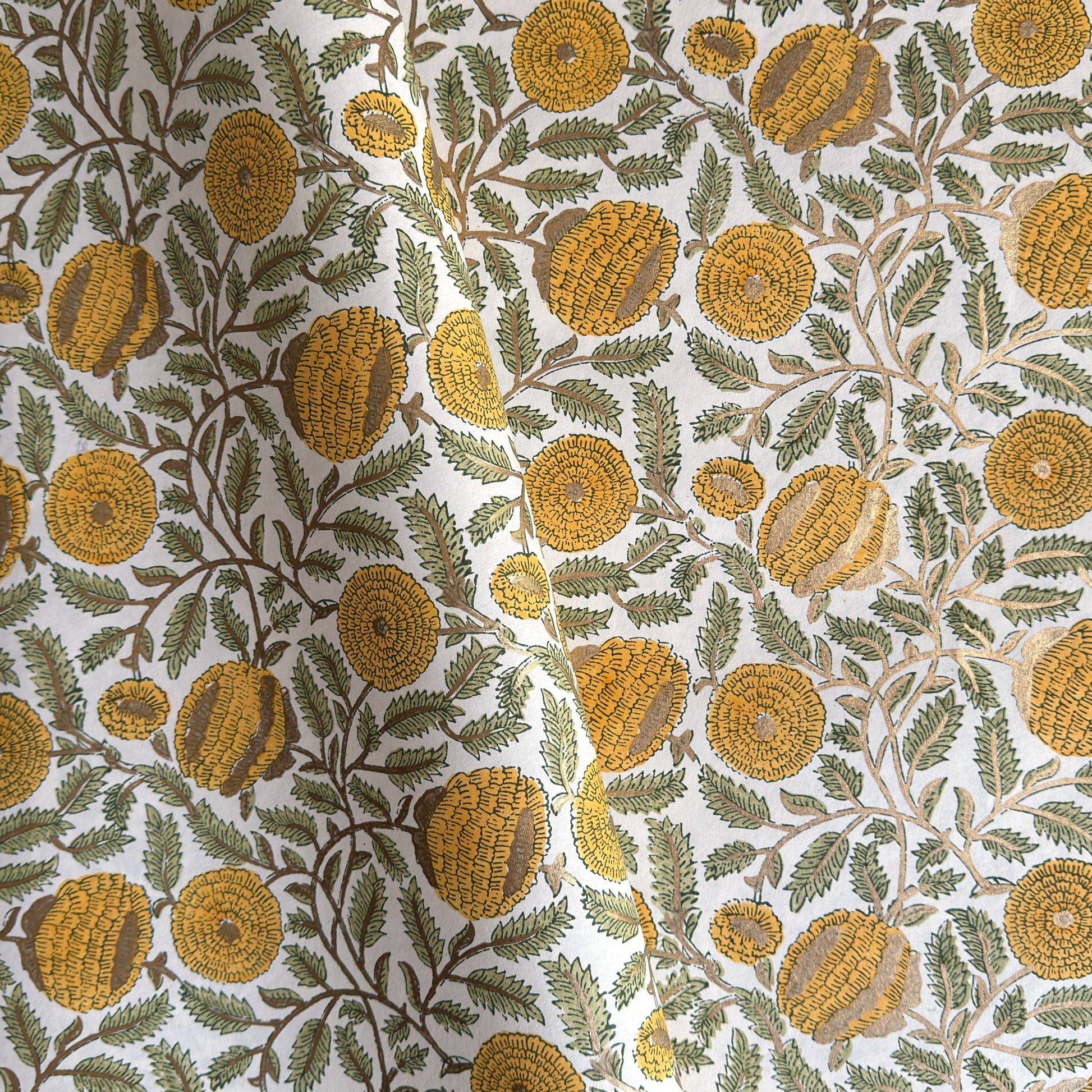 wrapping paper with repeat botanical pattern in yellow, gold and green by Paper Mirchi