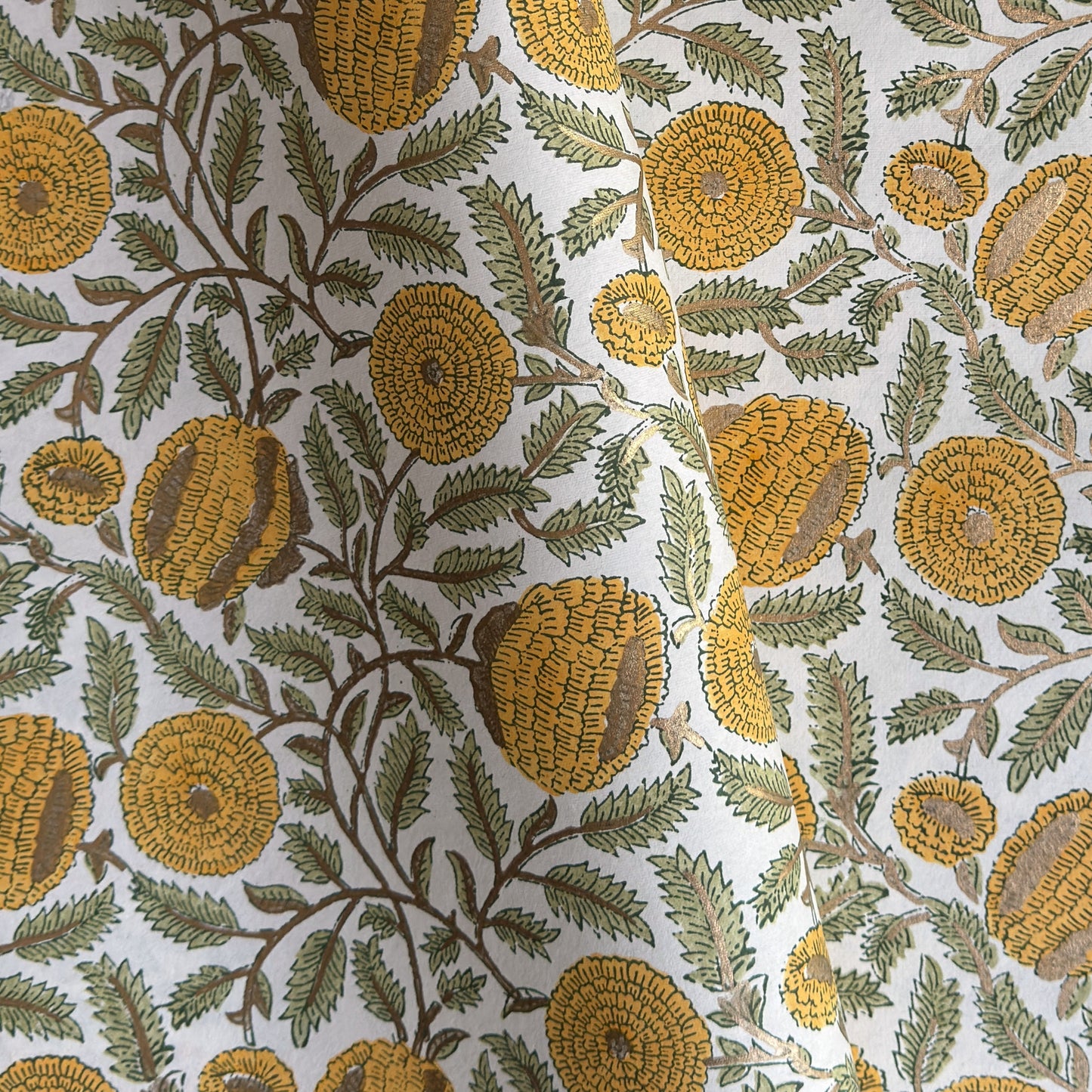 wrapping paper with repeat botanical pattern in yellow, gold and green by Paper Mirchi