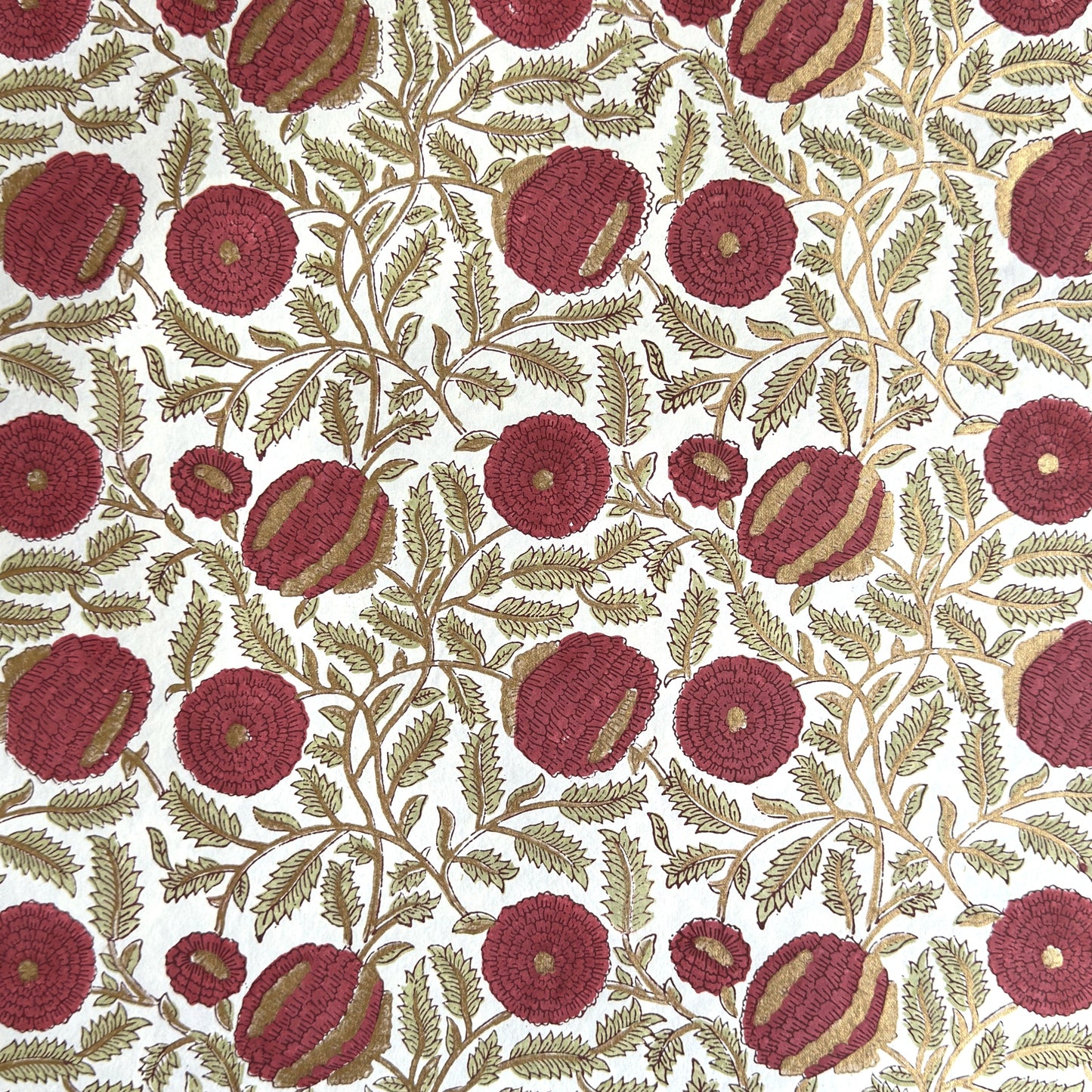 hand block printed paper by Paper Mirchi.  A floral repeat pattern in deep burgundy, pale green and gold.
