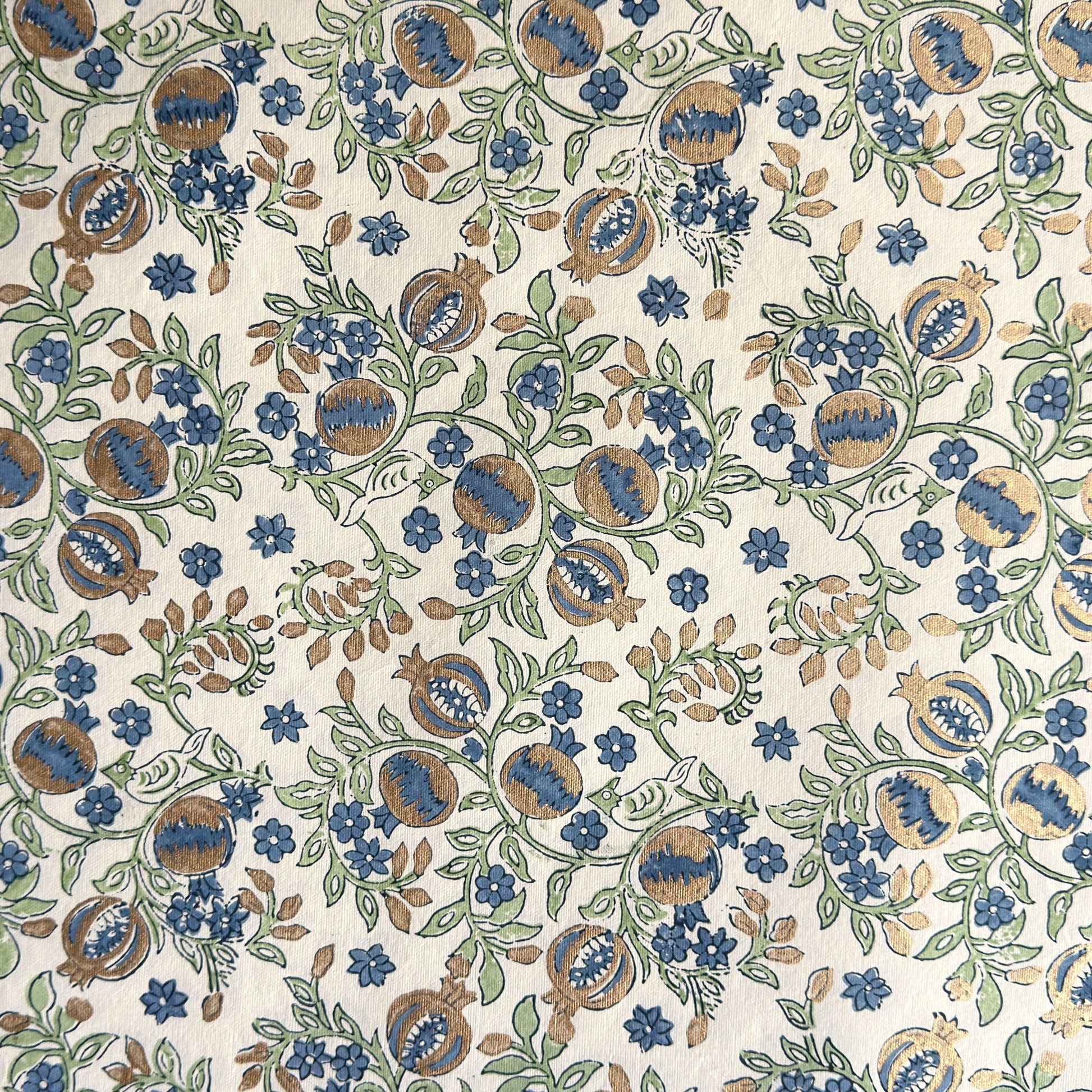hand block printed wrapping paper with a pomegranate design in indigo and green with gold accent. By Paper Mirchi