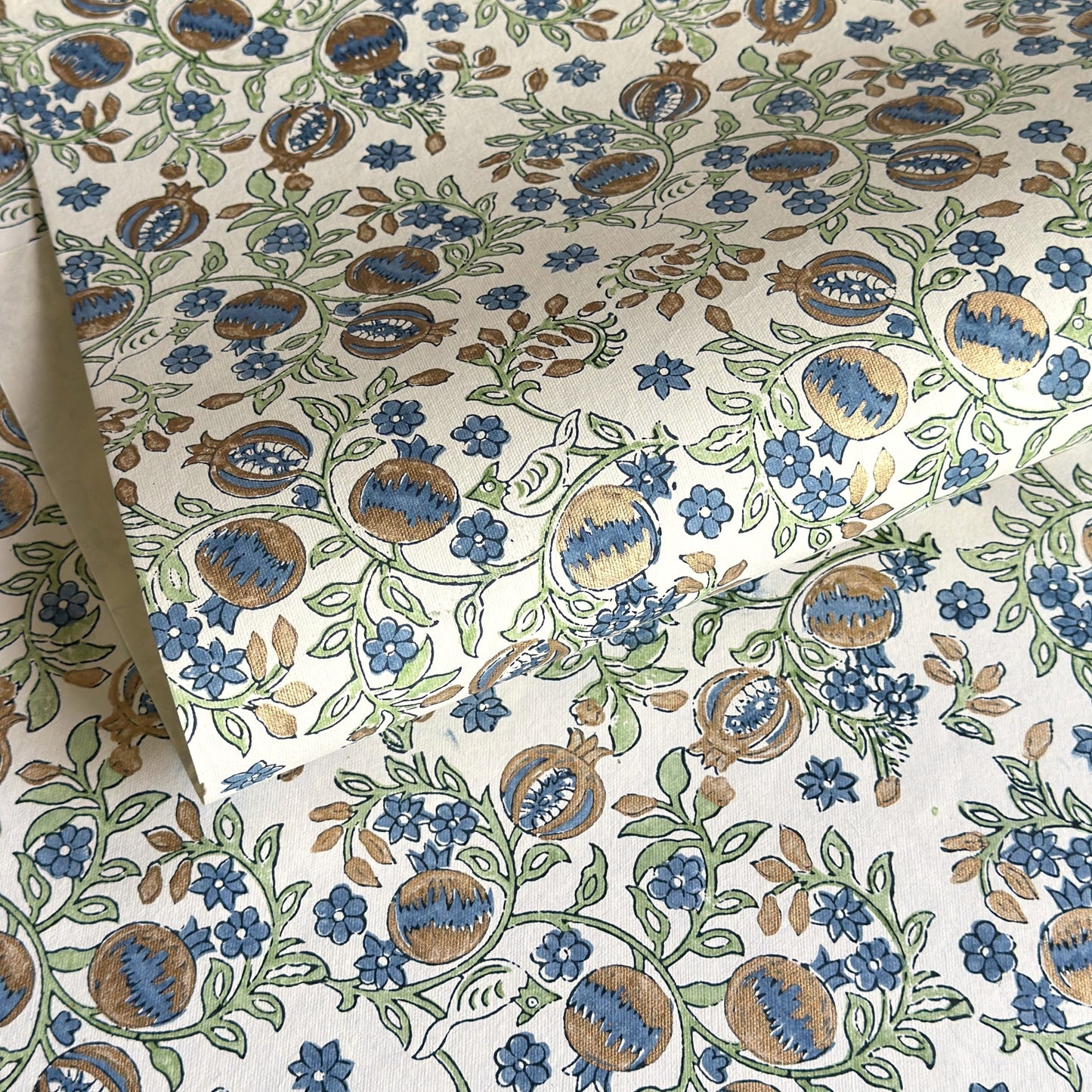 hand block printed wrapping paper with a pomegranate design in indigo and green with gold accent. By Paper Mirchi