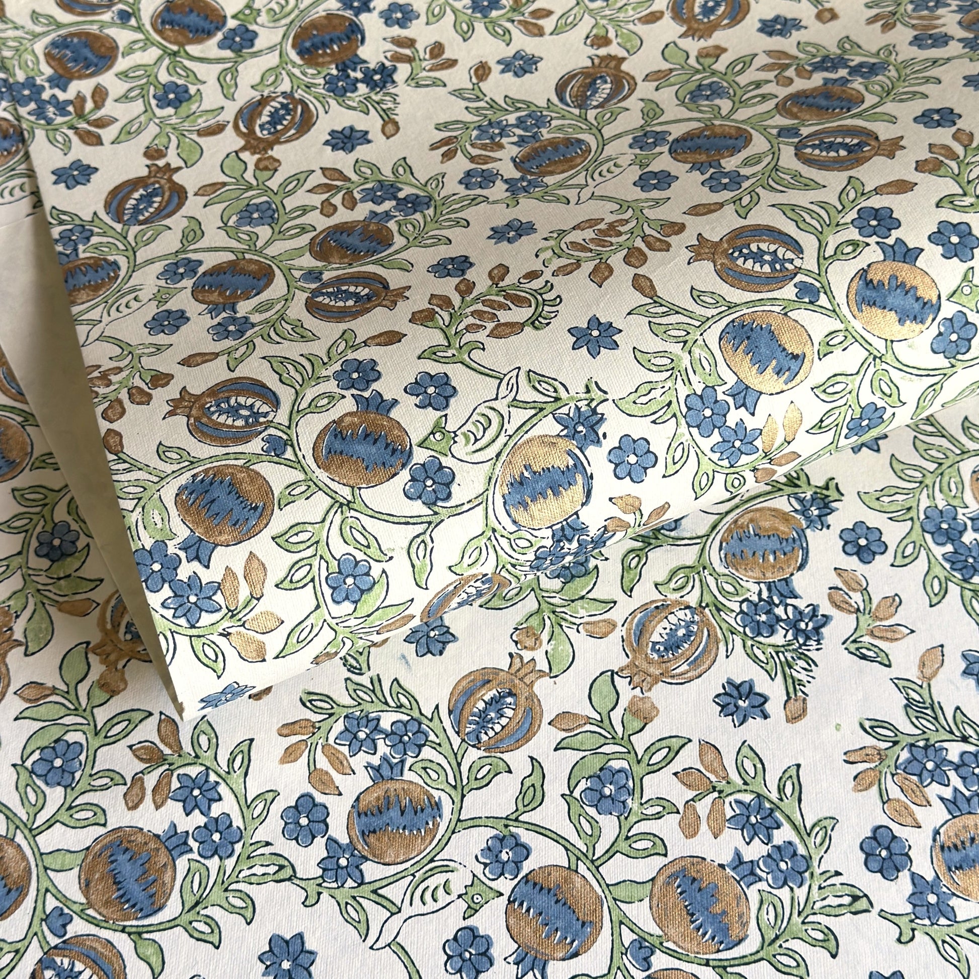 hand block printed wrapping paper with a pomegranate design in indigo and green with gold accent. By Paper Mirchi