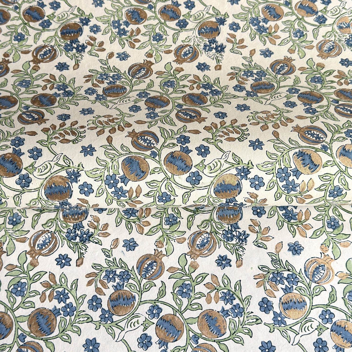 hand block printed wrapping paper with a pomegranate design in indigo and green with gold accent. By Paper Mirchi