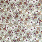 Hand block printed wrapping paper with a pattern of pomegranates in cherry red, green and gold.