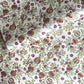 Hand block printed wrapping paper with a pattern of pomegranates in cherry red, green and gold.