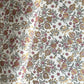 hand block printed wrapping paper by Paper Mirchi.  Repeat pattern of pomegranates in pink and green within a gold accent design.