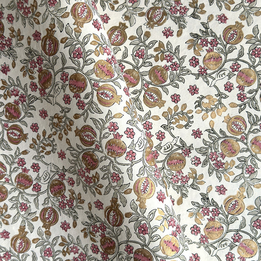 hand block printed wrapping paper by Paper Mirchi.  Repeat pattern of pomegranates in pink and green within a gold accent design.