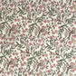 a sheet of hand-block printed wrapping paper with a pattern of a songbird amongst flowering branches in blush pink, soft green and gold