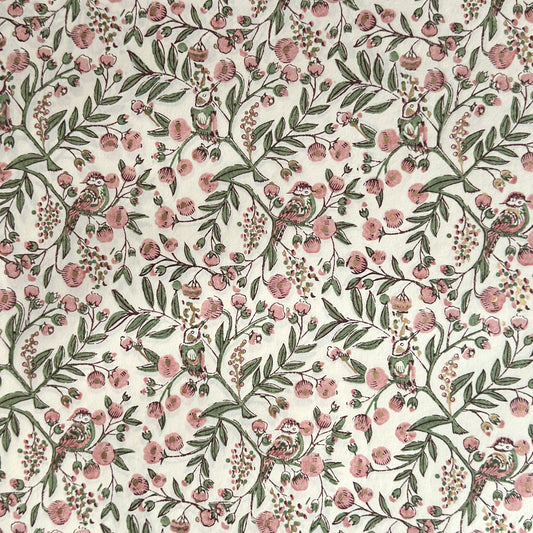 a sheet of hand-block printed wrapping paper with a pattern of a songbird amongst flowering branches in blush pink, soft green and gold