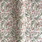 a sheet of hand-block printed wrapping paper with a pattern of a songbird amongst flowering branches in blush pink, soft green and gold