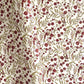 a sheet of hand block printed paper with a repeat pattern of foliage, flowers and a songbird in red, green and gold  
