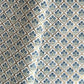 hand block printed wrapping paper with a small flower design in indigo and green surrounded by a gold trellis design. By Paper Mirchi