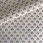 Hand block printed wrapping paper with a trellis pattern with flowers in cherry red, green and gold.