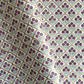 Hand block printed wrapping paper with a trellis pattern with flowers in cherry red, green and gold.