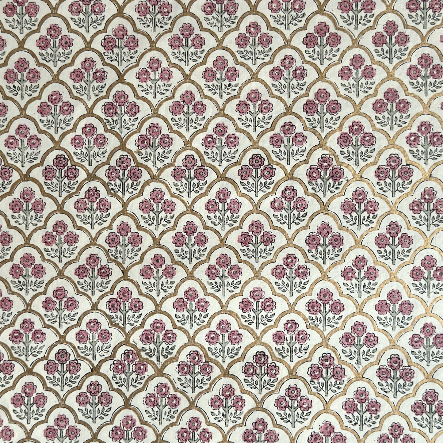 hand block printed wrapping paper by Paper Mirchi.  Repeat pattern of little flowers in pink and green within a gold trellis design.