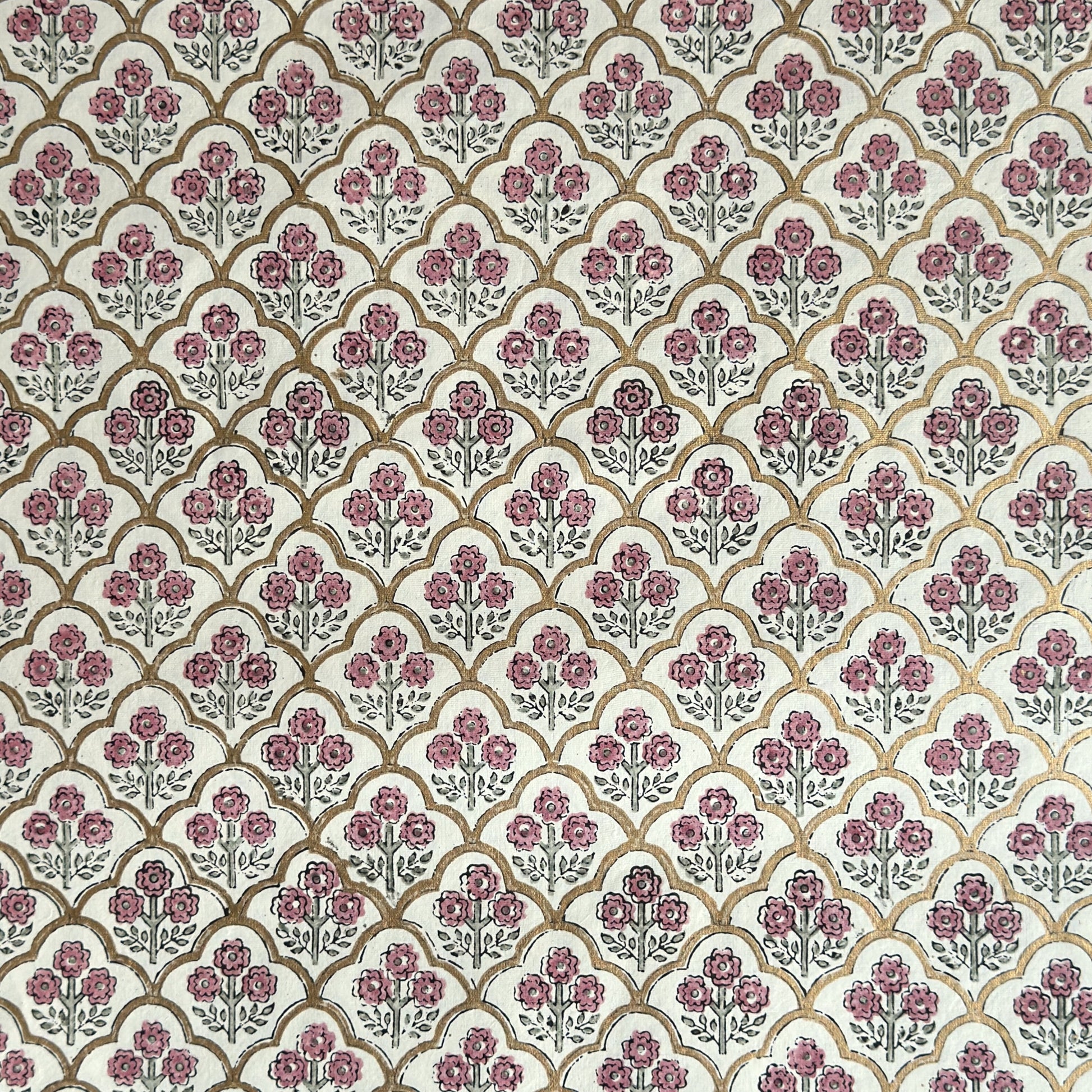 hand block printed wrapping paper by Paper Mirchi.  Repeat pattern of little flowers in pink and green within a gold trellis design.