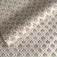 hand block printed wrapping paper by Paper Mirchi.  Repeat pattern of little flowers in pink and green within a gold trellis design.