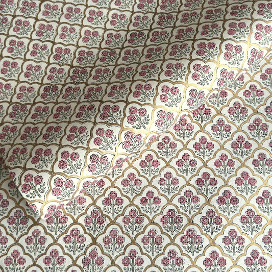 hand block printed wrapping paper by Paper Mirchi.  Repeat pattern of little flowers in pink and green within a gold trellis design.