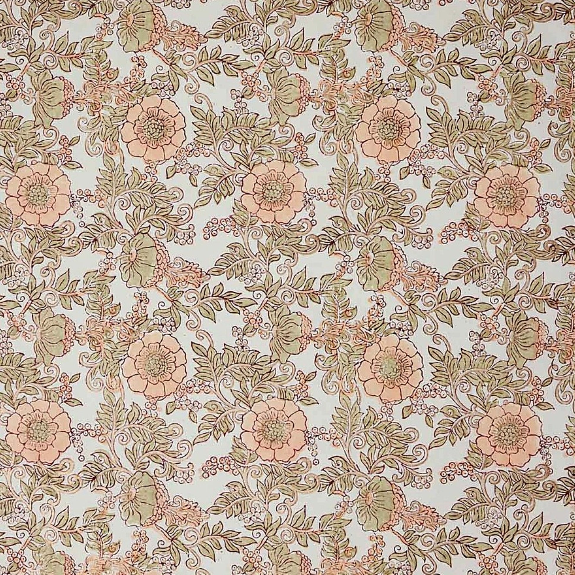 a hand block printed sheet of wrapping paper with a wild rose design in coral, moss green on a white background
