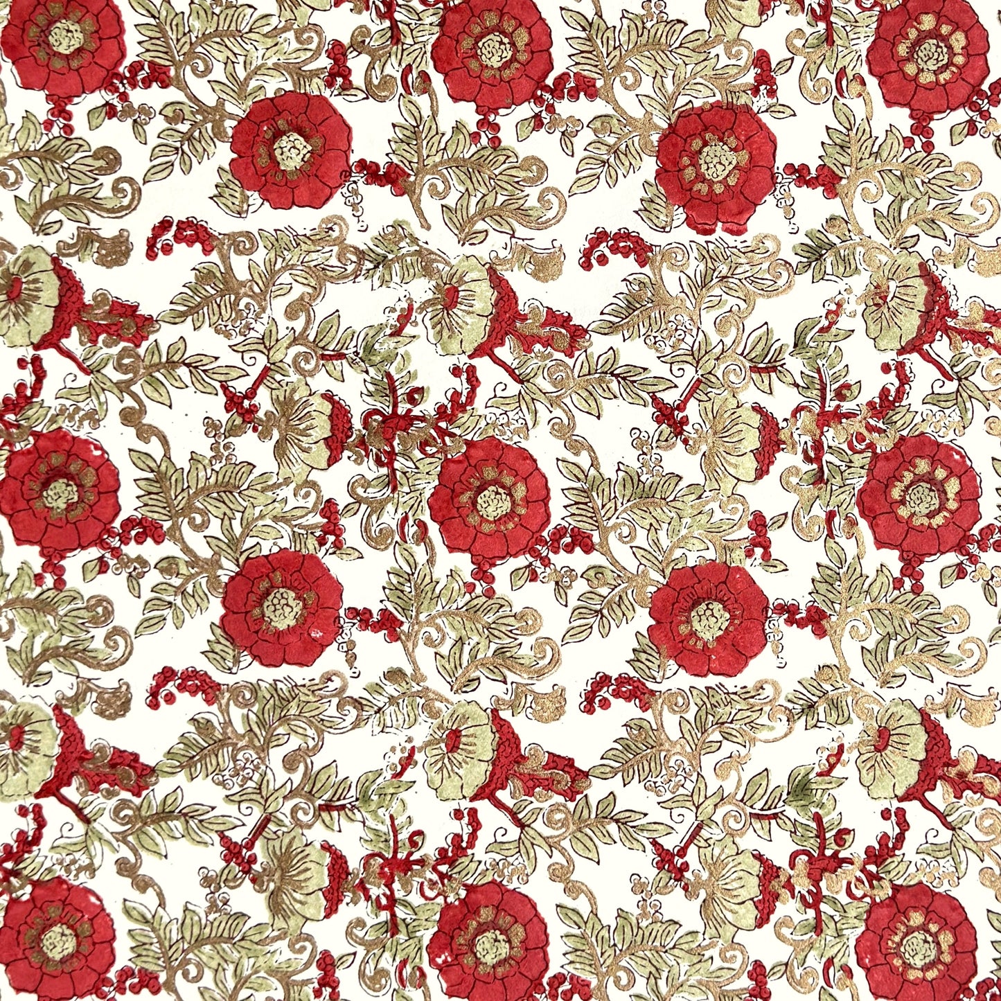 a sheet of hand block printed wrapping paper with a wild rose repeat design in scarlet red with soft green leaves and gold accents