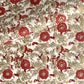 a sheet of hand block printed wrapping paper with a wild rose repeat design in scarlet red with soft green leaves and gold accents