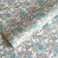 a sheet of hand block printed wrapping paper with a floral wild rose design in opal blue and gold