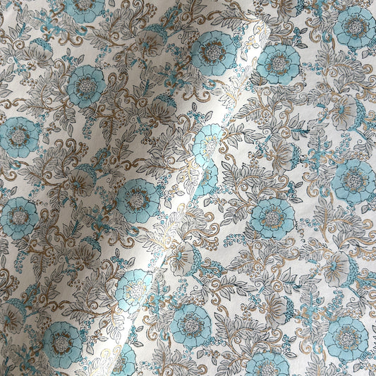 a sheet of hand block printed wrapping paper with a floral wild rose design in opal blue and gold