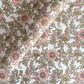 a hand block printed sheet of wrapping paper with a wild rose design in coral, moss green on a white background