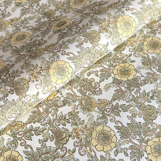 a sheet of hand block printed wrapping paper with a wild rose pattern in buttermilk yellow, moss green and gold