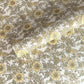 a sheet of hand block printed wrapping paper with a wild rose pattern in buttermilk yellow, moss green and gold
