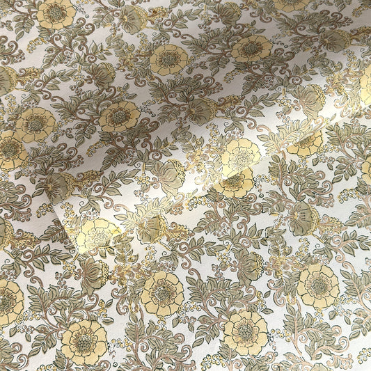 a sheet of hand block printed wrapping paper with a wild rose pattern in buttermilk yellow, moss green and gold