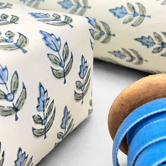 Wrapping paper with block print small flower motif in blue and grey-green, white background by Paper Mirchi
