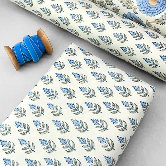 Wrapping paper with block print small flower motif in blue and grey-green, white background by Paper Mirchi