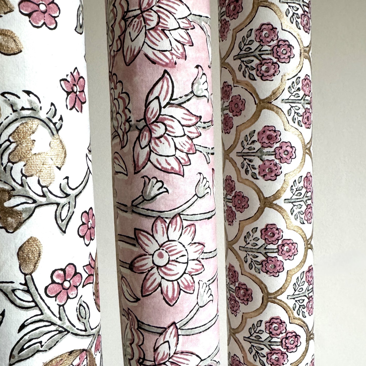 hand block printed wrapping paper by Paper Mirchi. Lotus flower repeat pattern in pale pink, pictured rolled with complementing designs