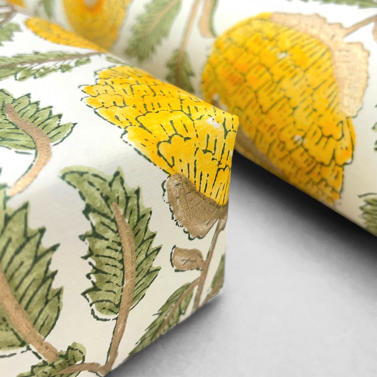 wrapping paper with repeat botanical pattern in yellow, gold and green by Paper Mirchi