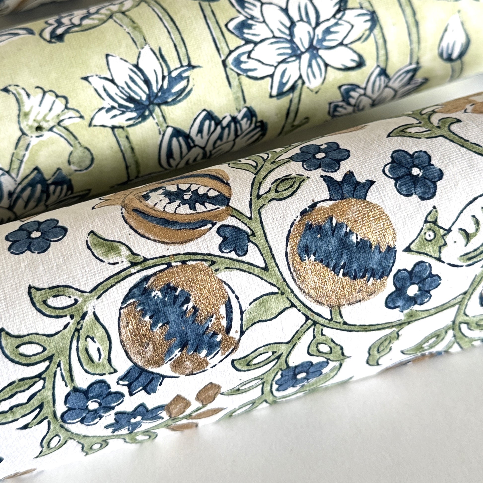 hand block printed wrapping paper with a pomegranate design in indigo and green with gold accent. By Paper Mirchi Close-up